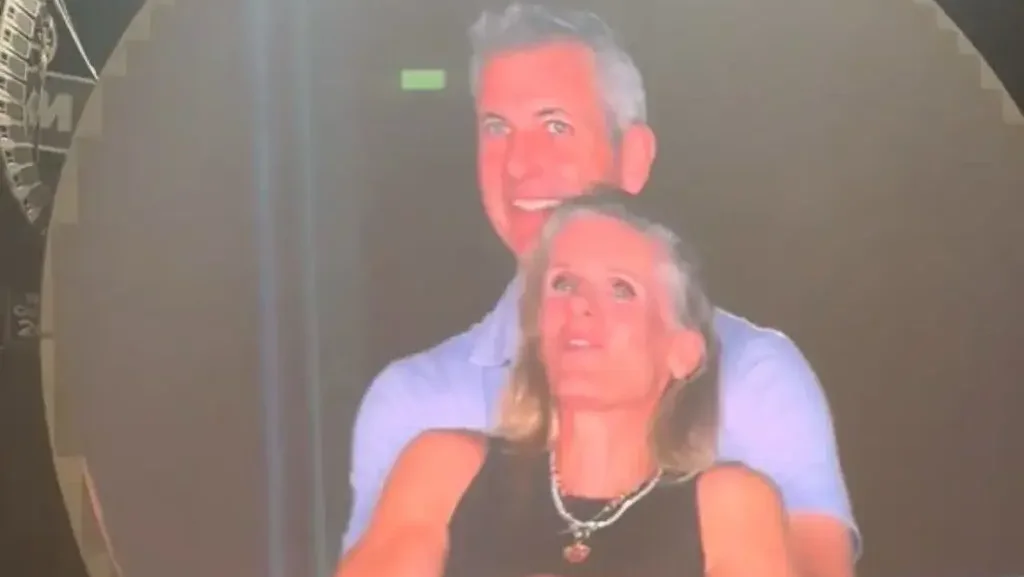 middle-aged couple smiling and embracing against a dark background