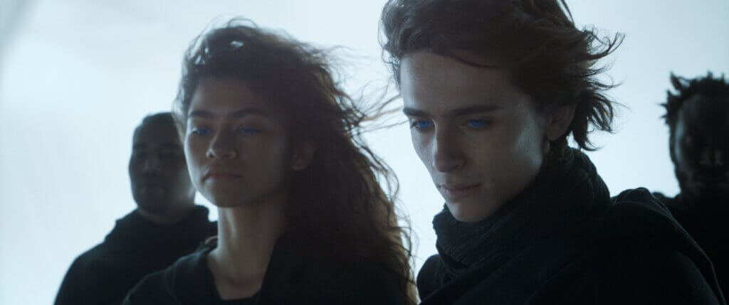 Zendaya and Timothée Chalamet with glowing blue eyes in a scene from Dune Part Two