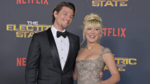 Actors Mason Gooding and Sydney Sweeney smiling on the red carpet at The Electric State Netflix premiere