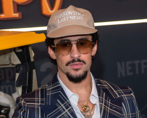 Actor and comedian Sebastian Maniscalco wearing a beige cap with "I WAS ON STAGE LAST NIGHT" text and sunglasses at a Netflix event
