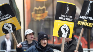 Protesters holding SAG-AFTRA on strike signs during a labor strike against AMPTP companies