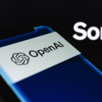 OpenAI logo displayed on a smartphone screen with the word "Sora" in the background.