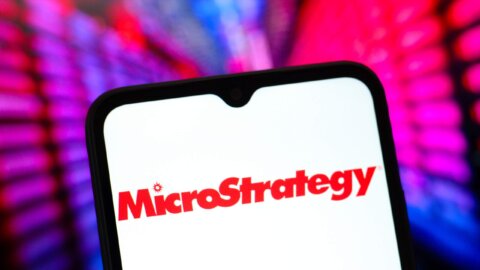 MicroStrategy logo displayed on a smartphone screen with colorful blurred background