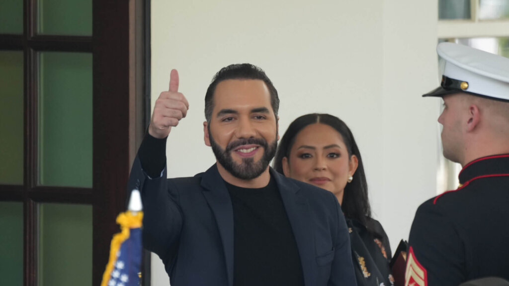 Nayib Bukele giving a thumbs up with a woman and a U.S. Marine in dress uniform nearby