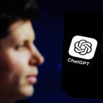 Person holding a smartphone displaying the ChatGPT app logo against a dark background.
