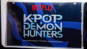 Vending machine selling Netflix K-pop Demon Hunters themed cans featuring animated characters and K-pop group Stray Boys.