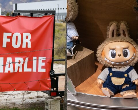 Red banner with white text "FOR CHARLIE" next to a plush toy with a furry hood and blue overalls sitting on a wooden shelf