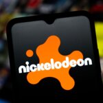 Nickelodeon logo displayed on a smartphone screen with a blurred colorful background.