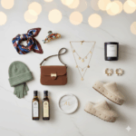 Brown leather handbag, layered gold necklaces, pearl hoop earrings, Byredo candle, cozy slippers, green knit hat and gloves, scarf, fish brooch, and olive oils.