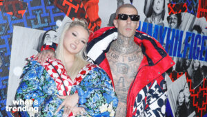 Two people posing in colorful Tommy Hilfiger jackets in front of a Tommy Hilfiger branded wall