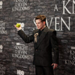 Actor Tom Glynn-Carney holding a green apple at the HBO premiere of A Knight of the Seven Kingdoms.