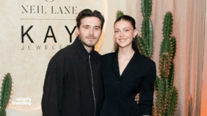 A man and woman posing together in front of a Neil Lane and Kay Jewelers sign with cacti in the background.