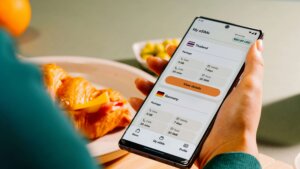 Person holding a smartphone displaying eSIM packages for Thailand and Germany with data, calls, and texts details.