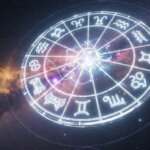 Glowing zodiac wheel with astrological signs against a starry cosmic background