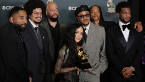 Musical group posing with a Grammy Award at a CBS event.