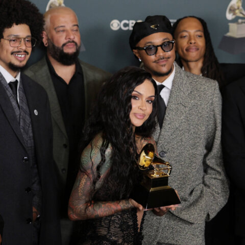 Musical group posing with a Grammy Award at a CBS event.