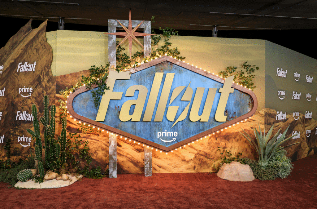 Fallout Prime promotional display with desert-themed backdrop and cacti on a red carpet.