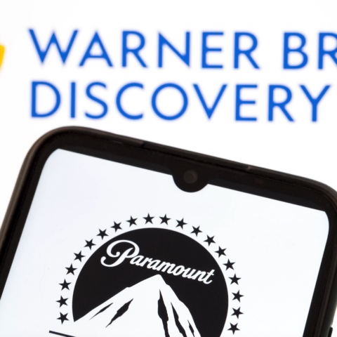 Paramount logo displayed on a smartphone screen with Warner Bros. Discovery logo in the background