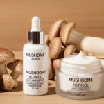 MUSHOME skincare products with mushrooms, including a dropper bottle and a cream jar on a wooden surface.