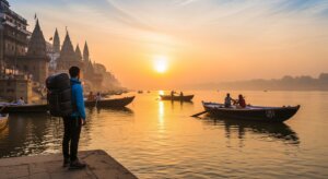 Traveler with backpack standing on riverbank at sunrise with boats and historic temples in Varanasi, India