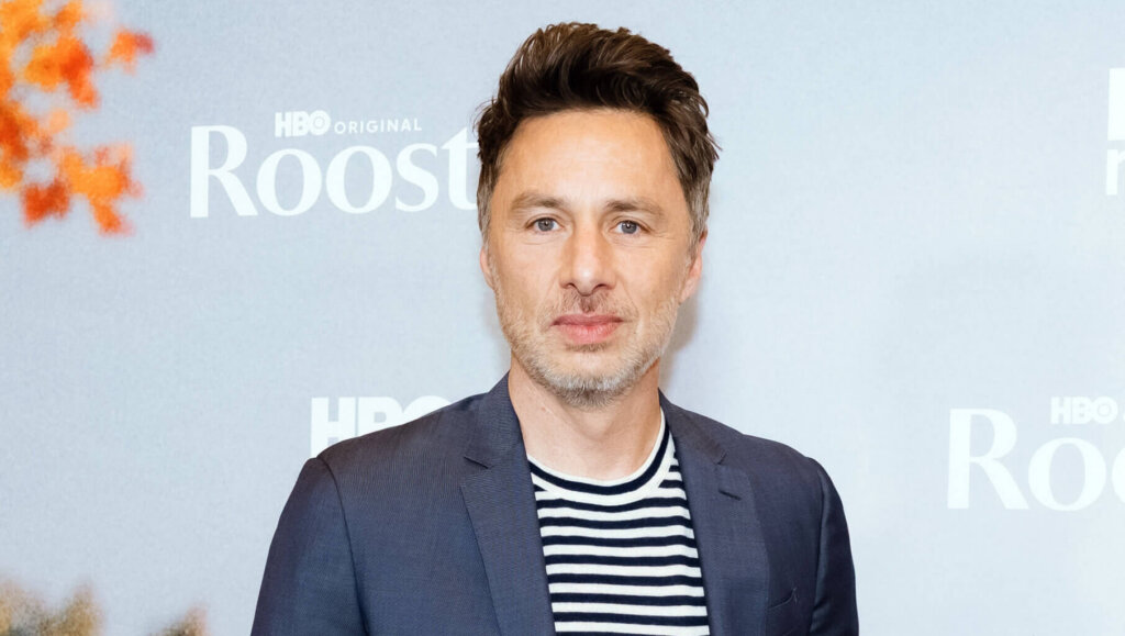 Zach Braff wearing a navy suit and striped shirt at the HBO Original Roost premiere event.