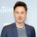 Zach Braff wearing a navy suit and striped shirt at the HBO Original Roost premiere event.