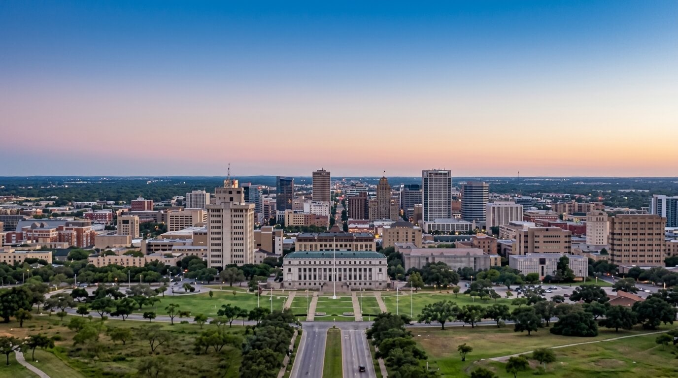 Aerial view of downtown Tulsa, Oklahoma at sunset with the Philbrook Museum of Art and surrounding buildings.