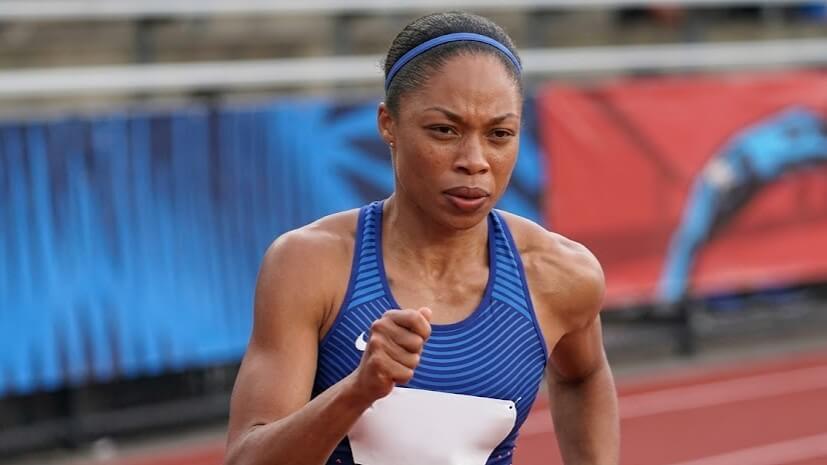 Female athlete in blue Nike sportswear sprinting on a track during a race