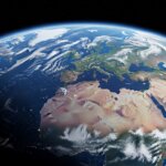 View of Earth from space showing Europe, Africa, and the Middle East with partial night lights and clouds.