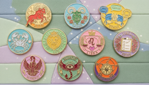 Colorful enamel pins featuring zodiac signs Aries, Taurus, Gemini, Cancer, Leo, Libra, Virgo, Scorpio, and Sagittarius on a pastel background