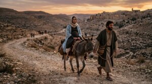 Man leading a donkey carrying a pregnant woman on a rocky path at sunset near an ancient town.