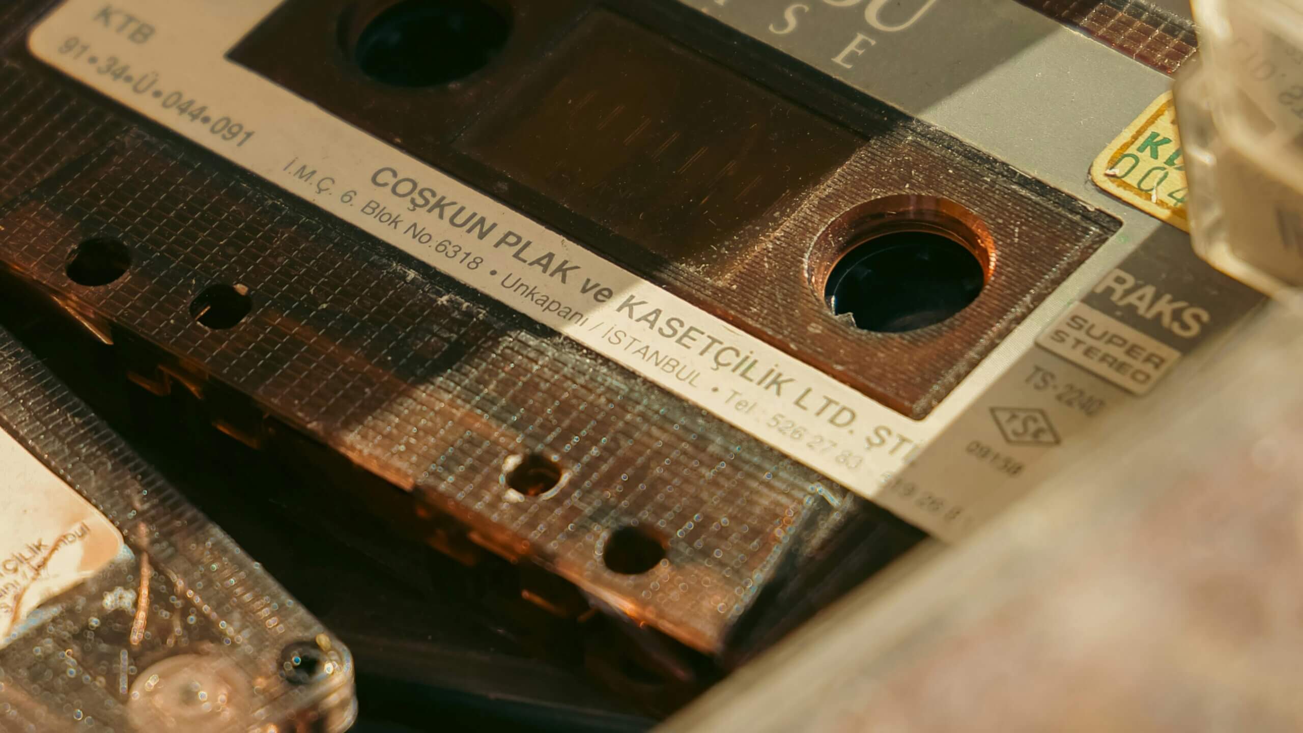 Close-up of a vintage RAKS Super Stereo audio cassette tape with Turkish label from Coşkun Plak ve Kasetçilik Ltd.