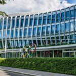 Modern glass building with the Olympic rings sculpture outside, headquarters of the International Olympic Committee.