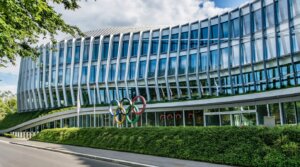 Modern glass building with the Olympic rings sculpture outside, headquarters of the International Olympic Committee.