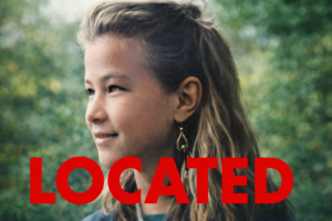 Smiling young girl with long hair and gold earrings, with the word "LOCATED" in bold red letters across the image.