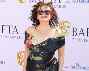 Susan Sarandon smiling in floral off-shoulder dress and red sunglasses at BAFTA Television Awards 2023