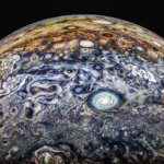 Close-up of Jupiter's swirling cloud patterns and storms against black space background.