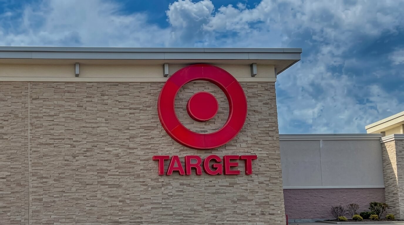Target store logo on a beige brick building exterior under a partly cloudy sky