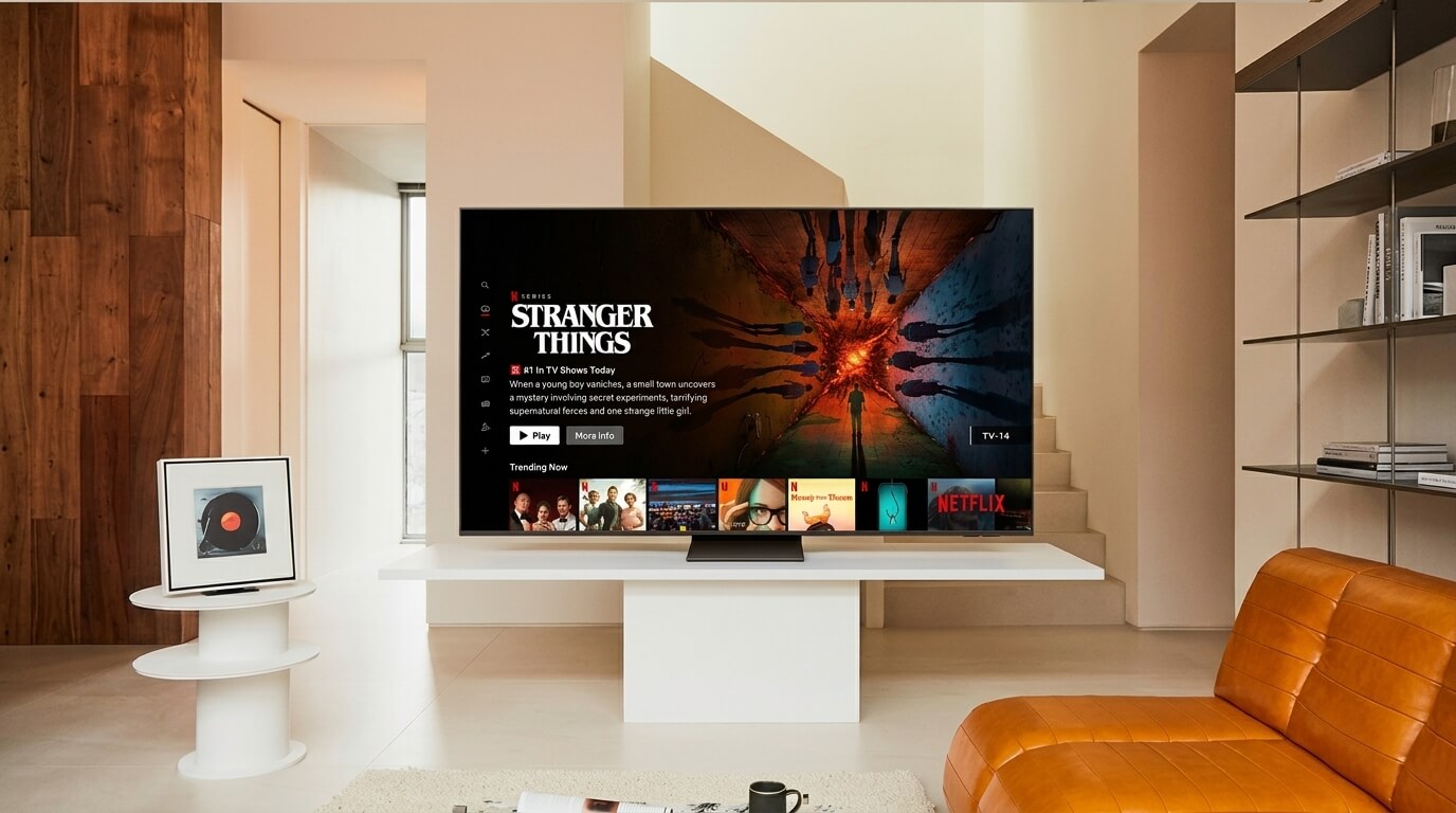 Netflix interface displaying Stranger Things on a modern flat-screen TV in a minimalist living room.