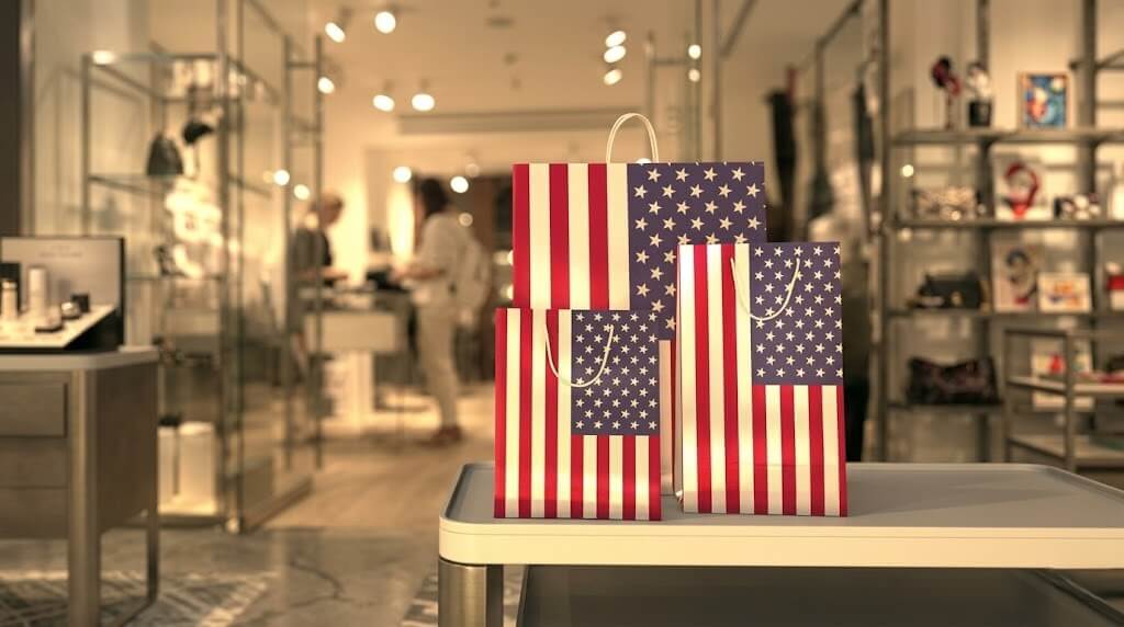 Three shopping bags with American flag design on a table inside a retail store.
