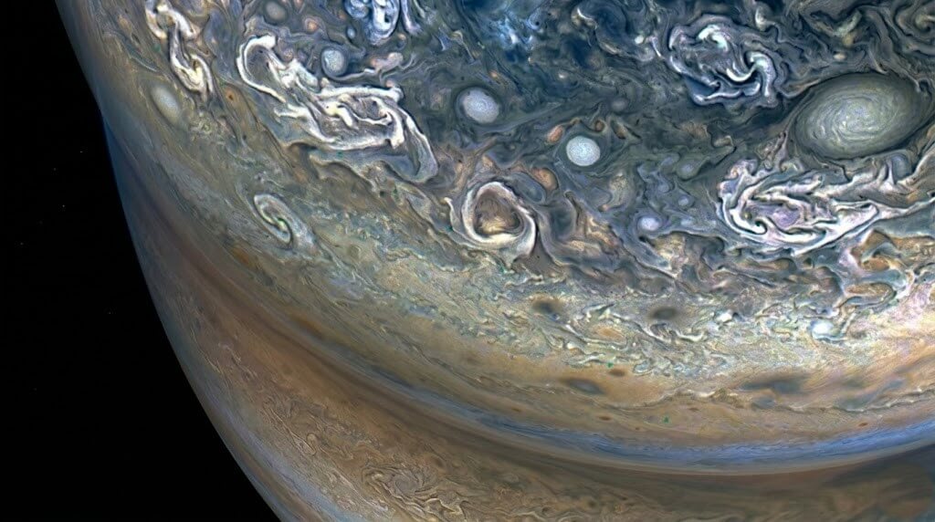 Close-up view of Jupiter's swirling cloud patterns and storms in its atmosphere.