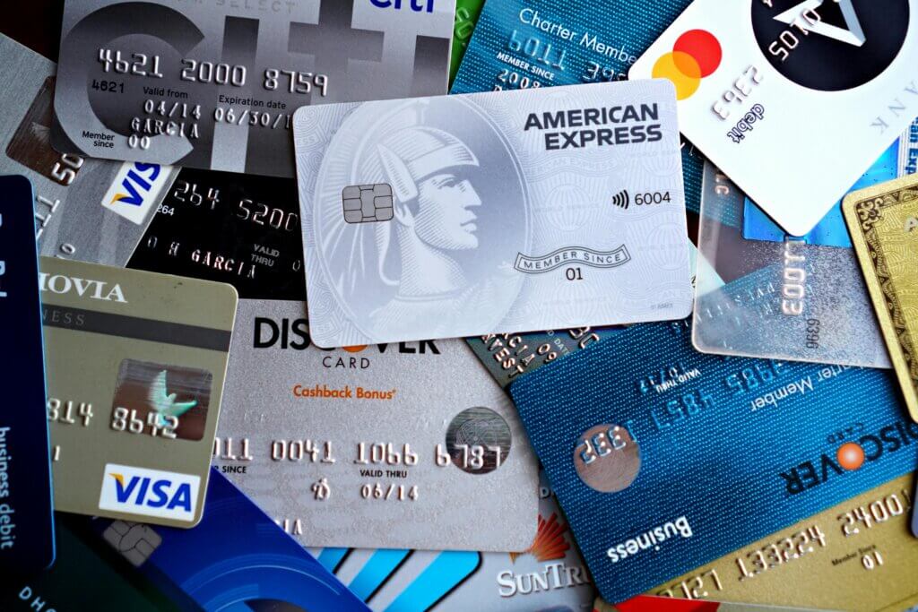 Various credit cards including American Express, Visa, Mastercard, Discover, and Citi overlapping in a pile.