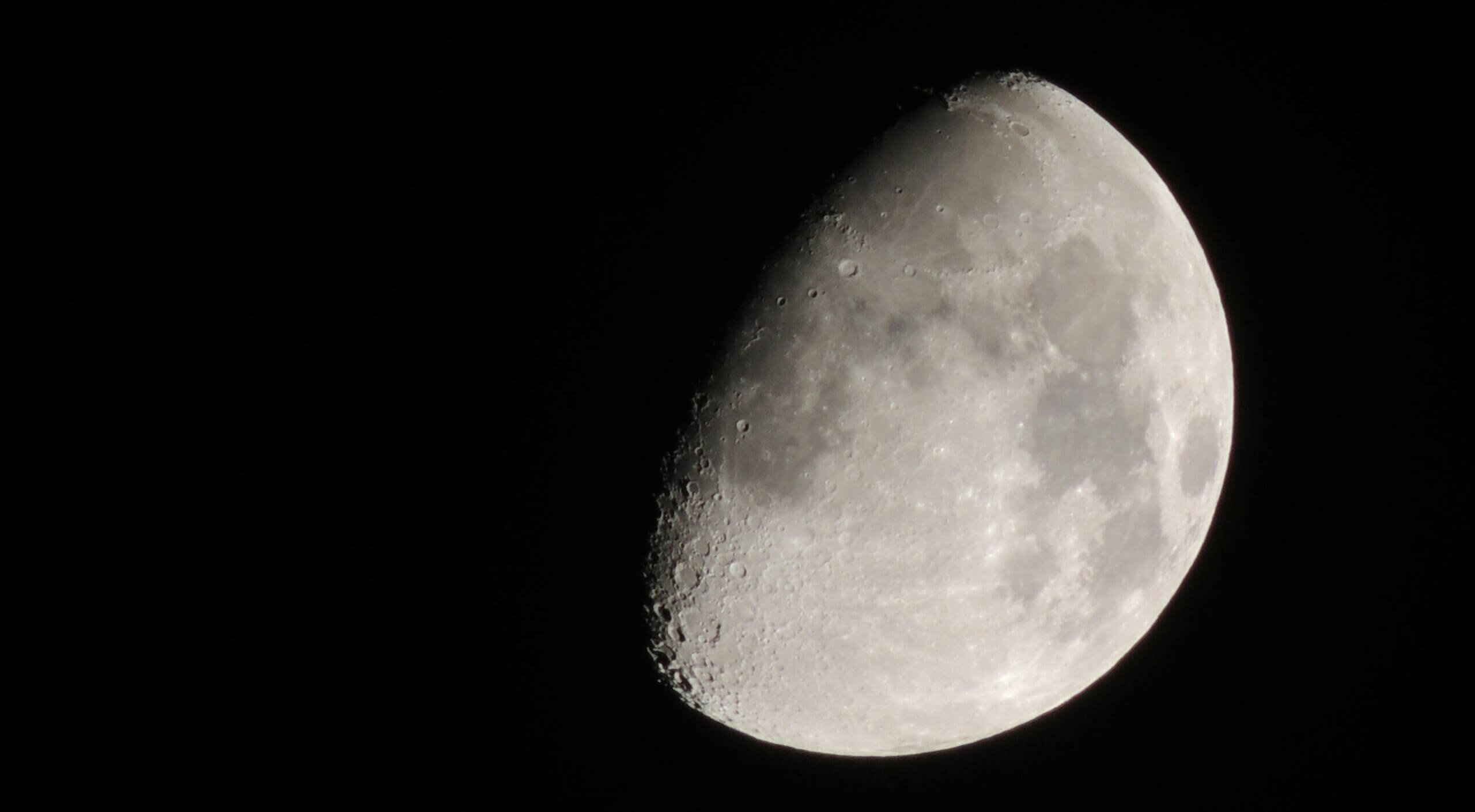 Waning gibbous moon showing detailed craters and surface texture against a black night sky