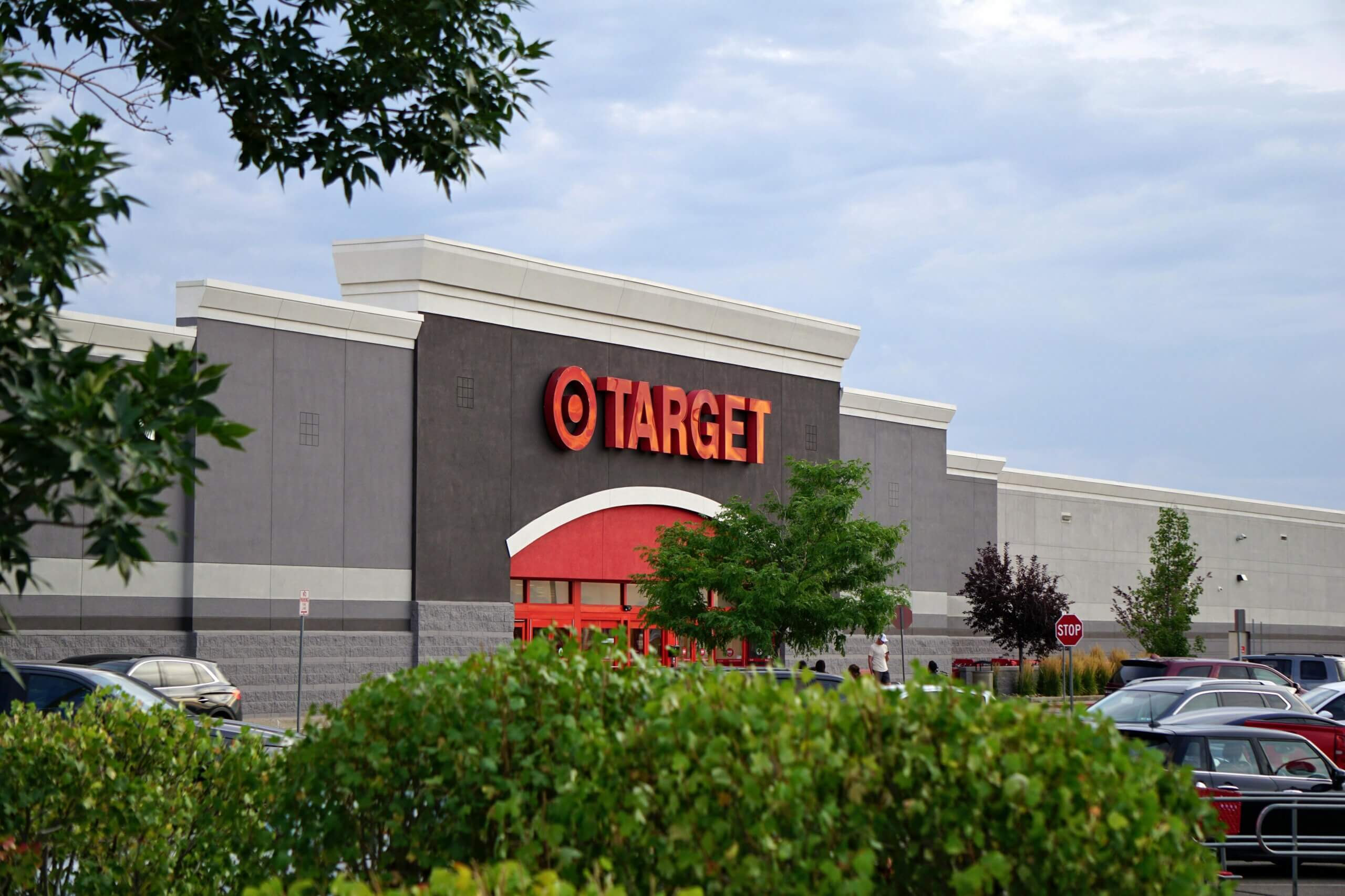 Target store exterior with parking lot and greenery in the foreground under a cloudy sky