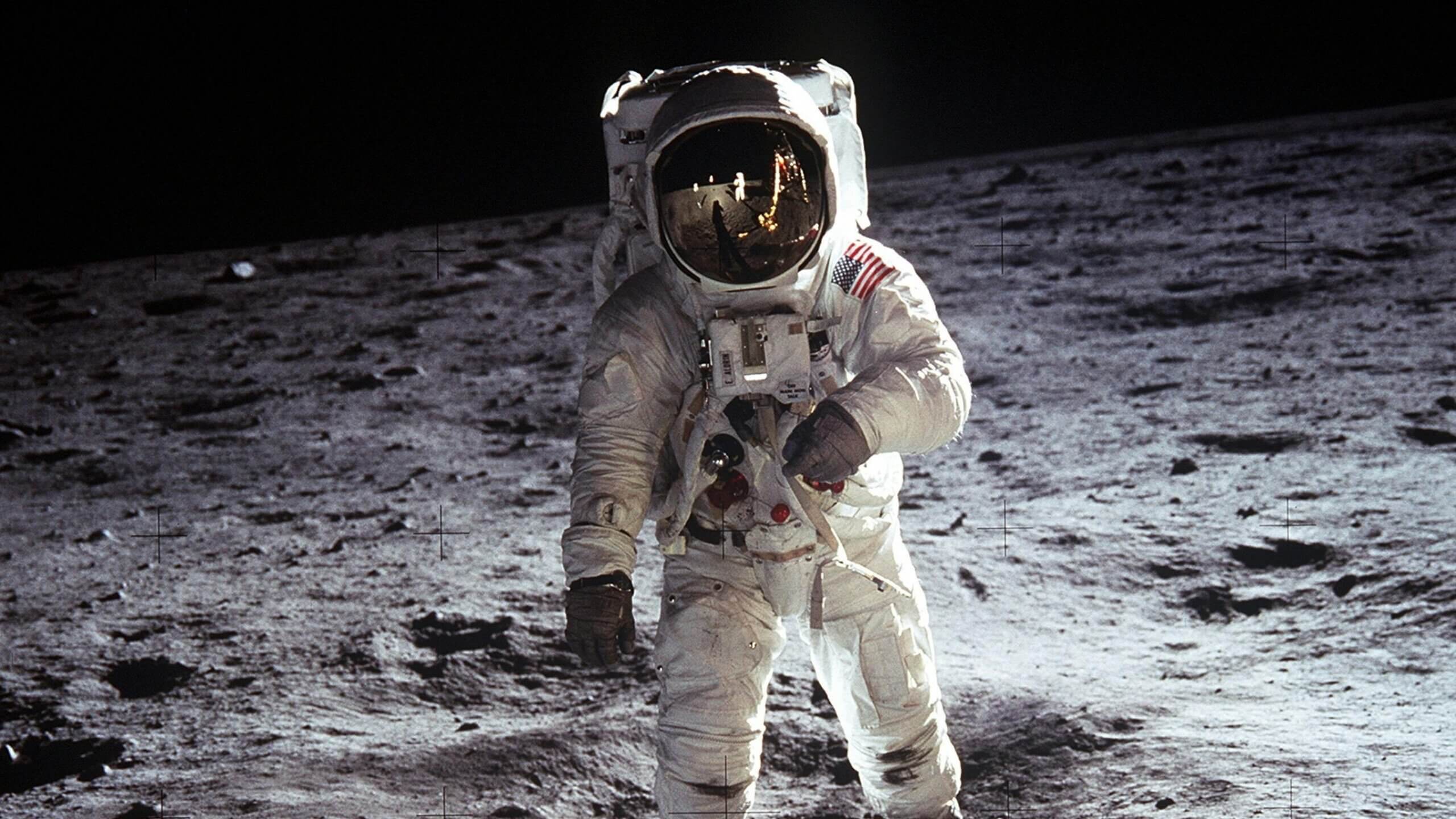 Astronaut Buzz Aldrin on the moon during Apollo 11 mission with lunar surface and black sky background