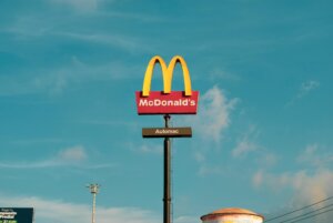 McDonald's golden arches sign with "Automac" under a clear blue sky