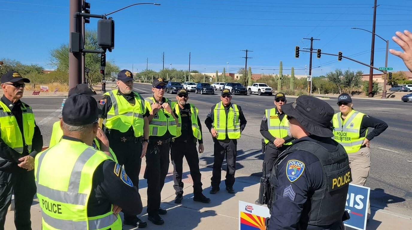 Group of police officers and volunteers in yellow vests standing on a street corner in Arizona during daytime