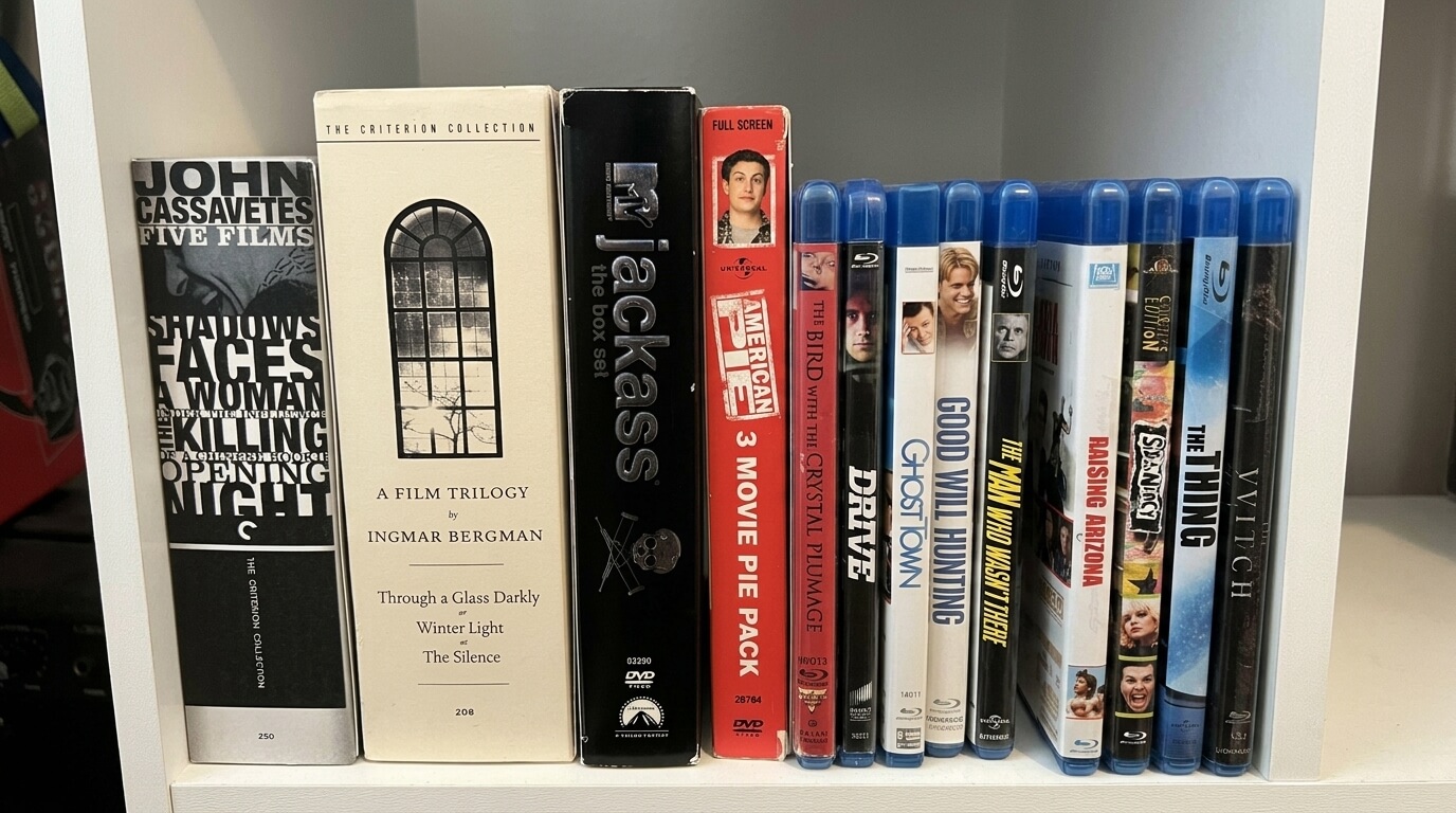 DVD and Blu-ray collection including John Cassavetes Five Films, Ingmar Bergman Trilogy, My Jackass box set, American Pie 3 Movie Pack, The Bird with the Crystal Plumage, Drive, Ghost Town, Good Will Hunting, The Man Who Wasn't There, Raising Arizona, Slumdog Millionaire, The Thing, and Witch.