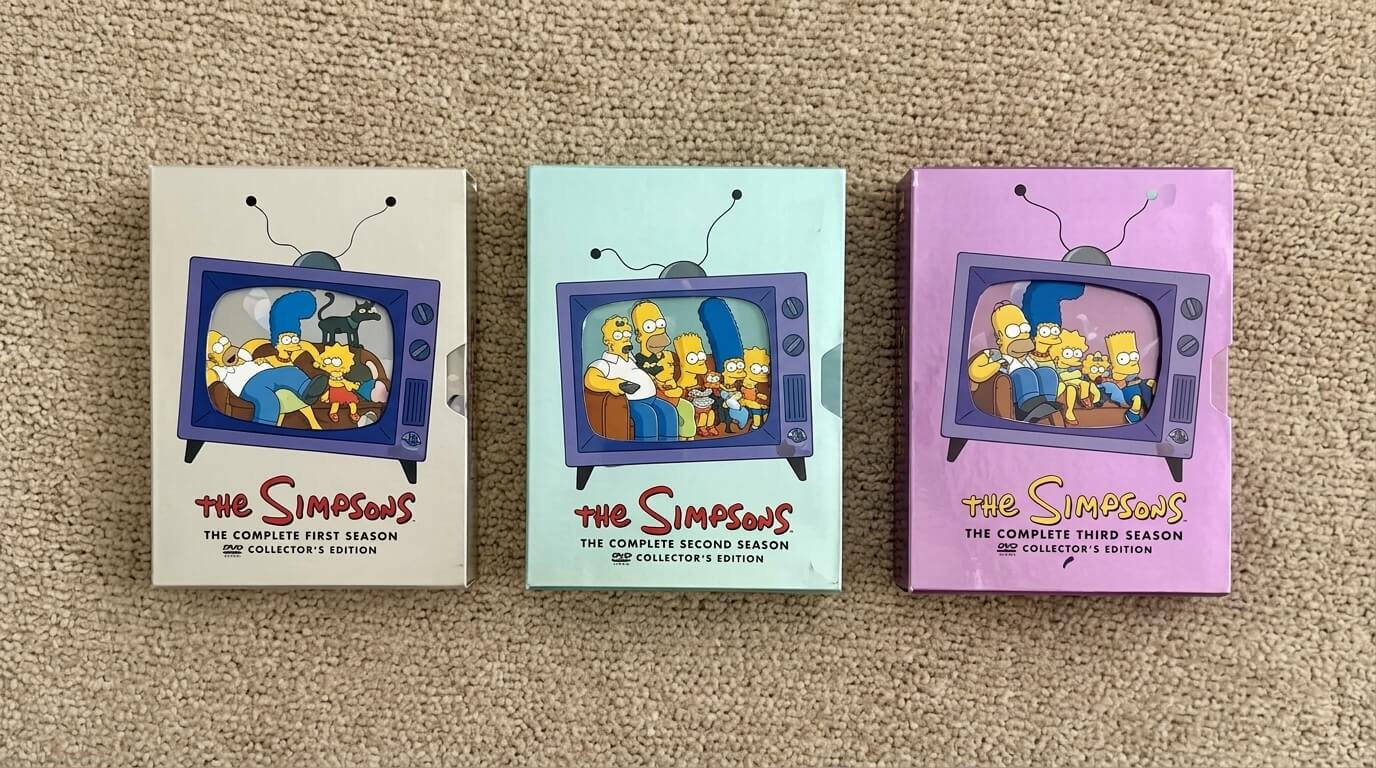 The Simpsons complete first, second, and third season DVD collector's editions with TV screen artwork on carpet background.