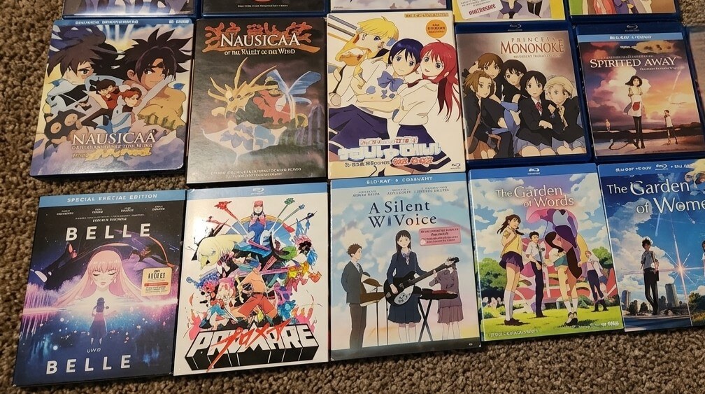 Blu-ray covers of Studio Ghibli and other anime films including Nausicaä, Belle, Promare, A Silent Voice, The Garden of Words, and Spirited Away.